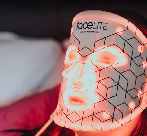 Model wearing FaceLite flexible LED mask with red light therapy, geometric grid design