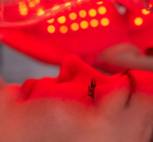 Close-up of person receiving red LED light therapy treatment