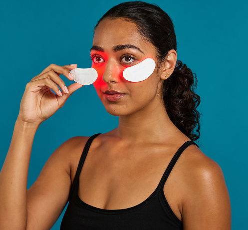 Model using under-eye LED light therapy patches