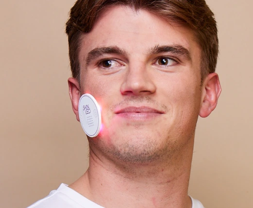 Male model applying iSmart Acne LED Patch for spot treatment and clearer skin
